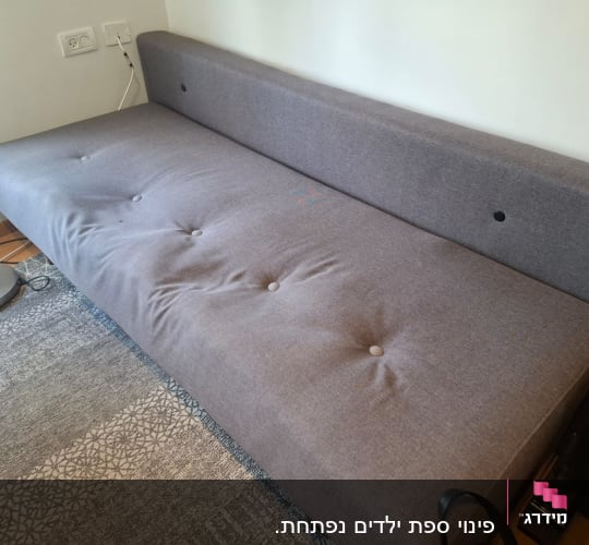 ספה אפורה עם כפתורים על שטיח מעוצב